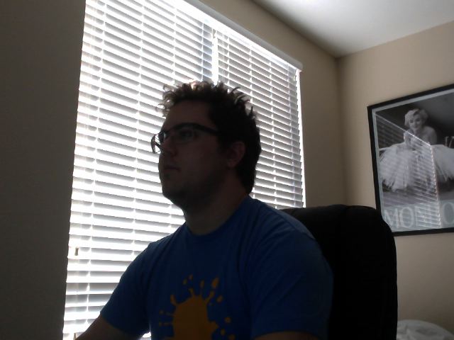  No, that's not my poster. My girlfriend got to decorate that side of the room.   Yes, It makes Skype calls awkward. Then again, so does that hair. 